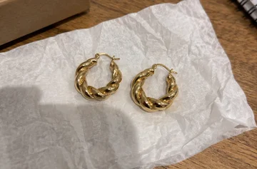 Original photo of gold-tone earrings on tissue paper on a table
